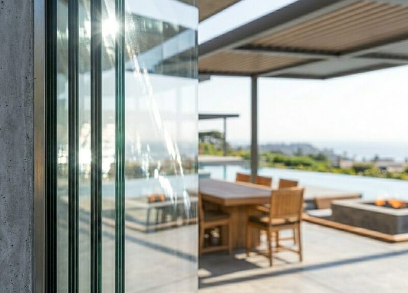 Close up macro architectural photo focusing on the exposed edge of a thick, triple-glazed high-span glass panel, emphasizing its thermal efficiency structure.